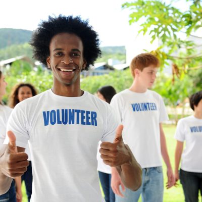 happy volunteer african american man showing thumbs up sign